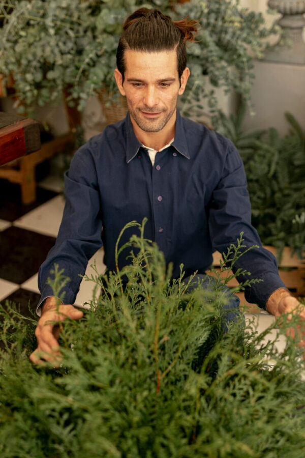 homme qui tient un bouquet d'eucalyptus